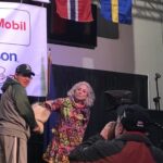 Musher DeeDee Jonrowe pulls a number from the traditional mukluk (boot). Photo Credit: Davis Hovey, KNOM (2018)