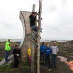 Nick Hanson practices the salmon ladder obstacle on the course he built out of driftwood. Photo: Laura Kraegel, KNOM.