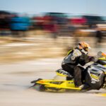 A snowmachine rider screams past the starting line of the Nome-Golovin Snowmachine Race.