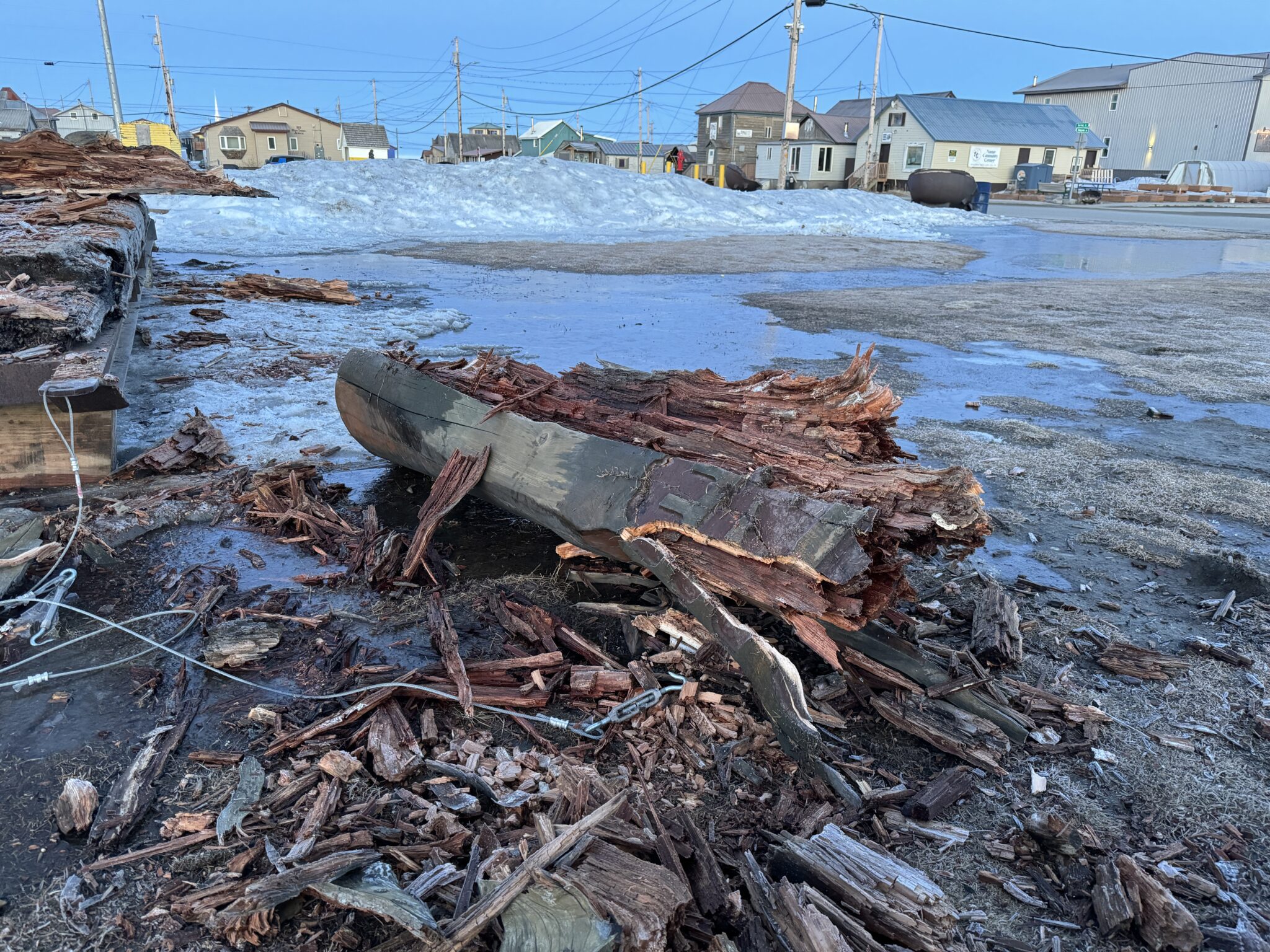 The beam that spans the two pillars lies in ruin on the ground. The beginning of the inscription "End of Iditarod Sled Dog Race" can be observed. Ben Townsend photo.