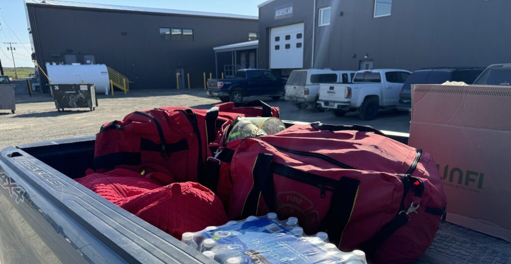 Red bags of gear with bottled water ready to be loaded on a plane to Stebbins. Ben Townsend photo.