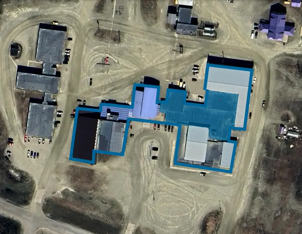 The roof of Nome Beltz Middle High School with a blue highlight over the location of the base bid specification from 2022's RFP. Graphic: Google Earth/ KNOM