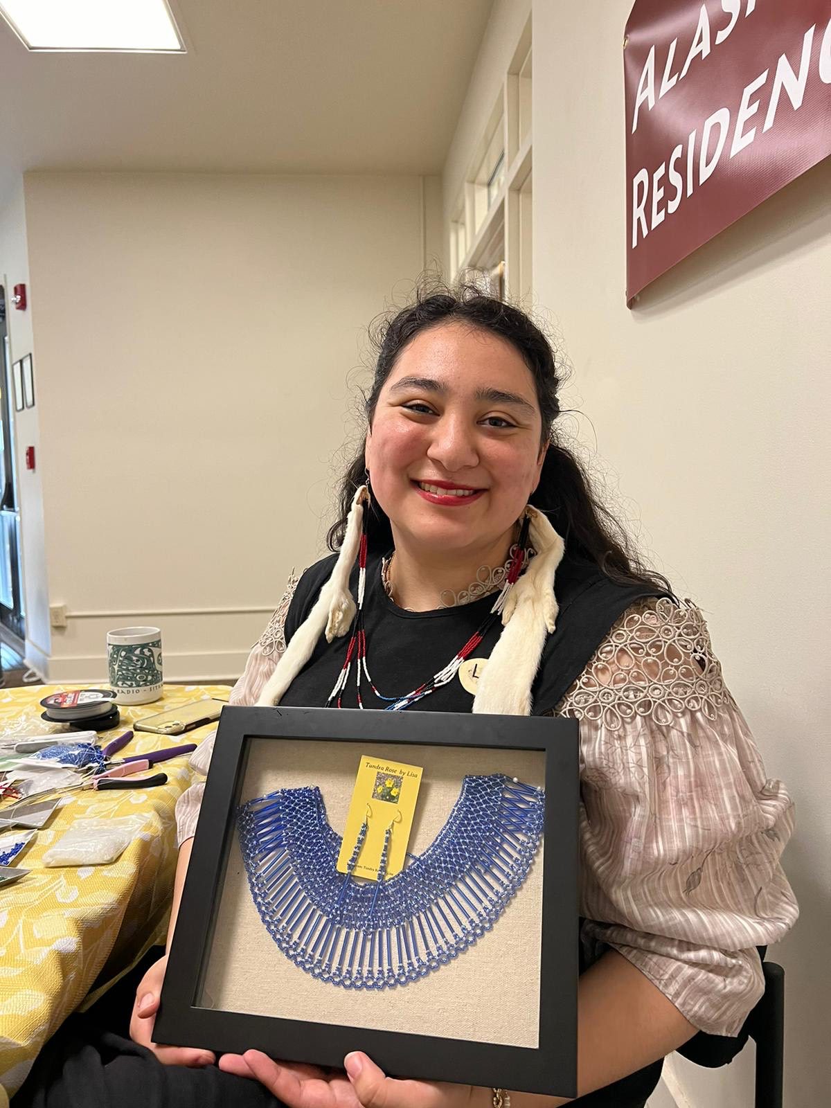 Lisa Lynch shows off a handmade blue necklace in a display case. Photo courtesy of Lisa Lynch.