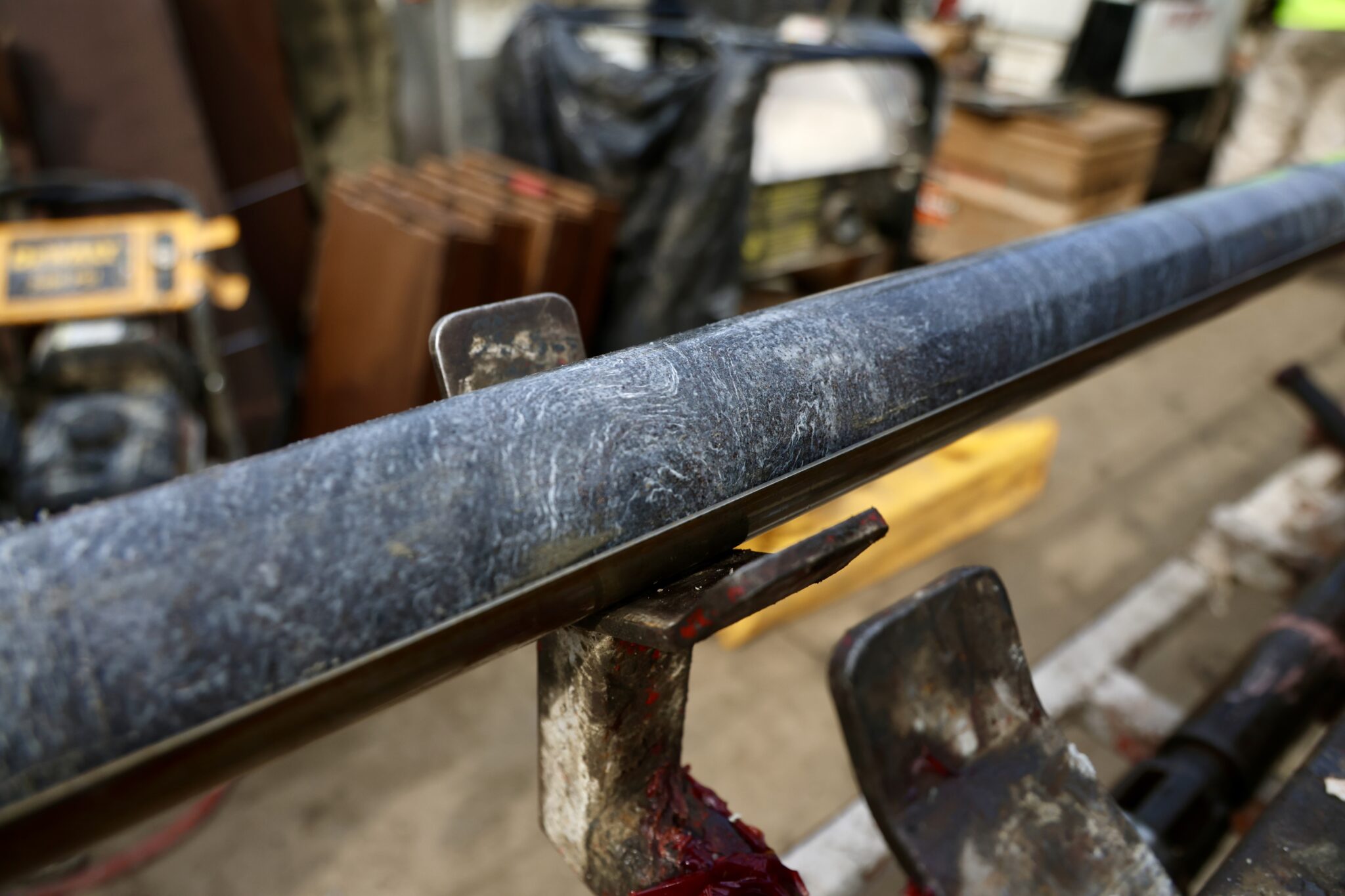 A dark, slick core sample suggesting high graphite mineralization. 