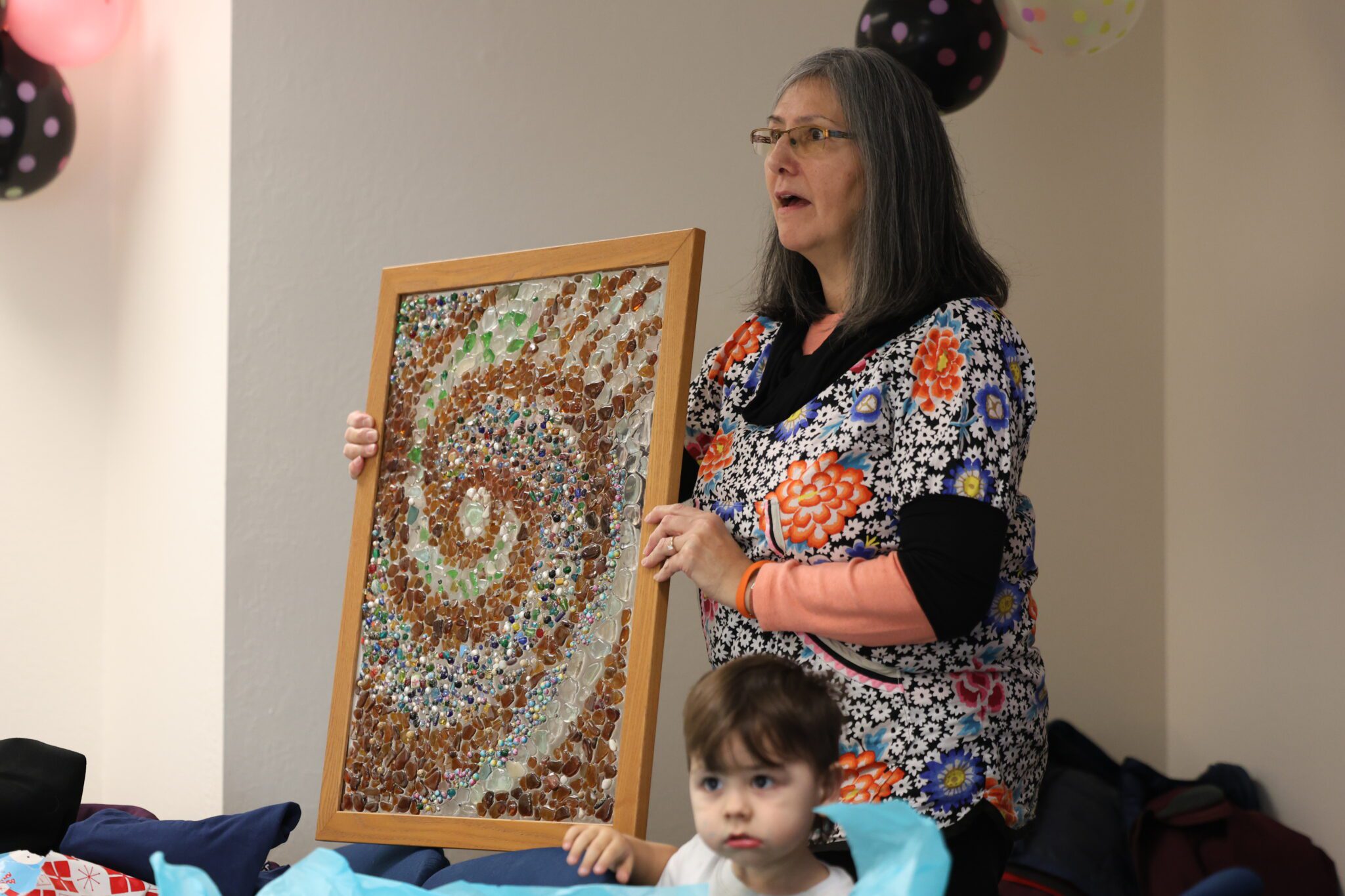 Sue Luke shows off beach glass art by Karen Olanna. The piece was gifted to Luke by Claudia Ihl. Ben Townsend photo.  