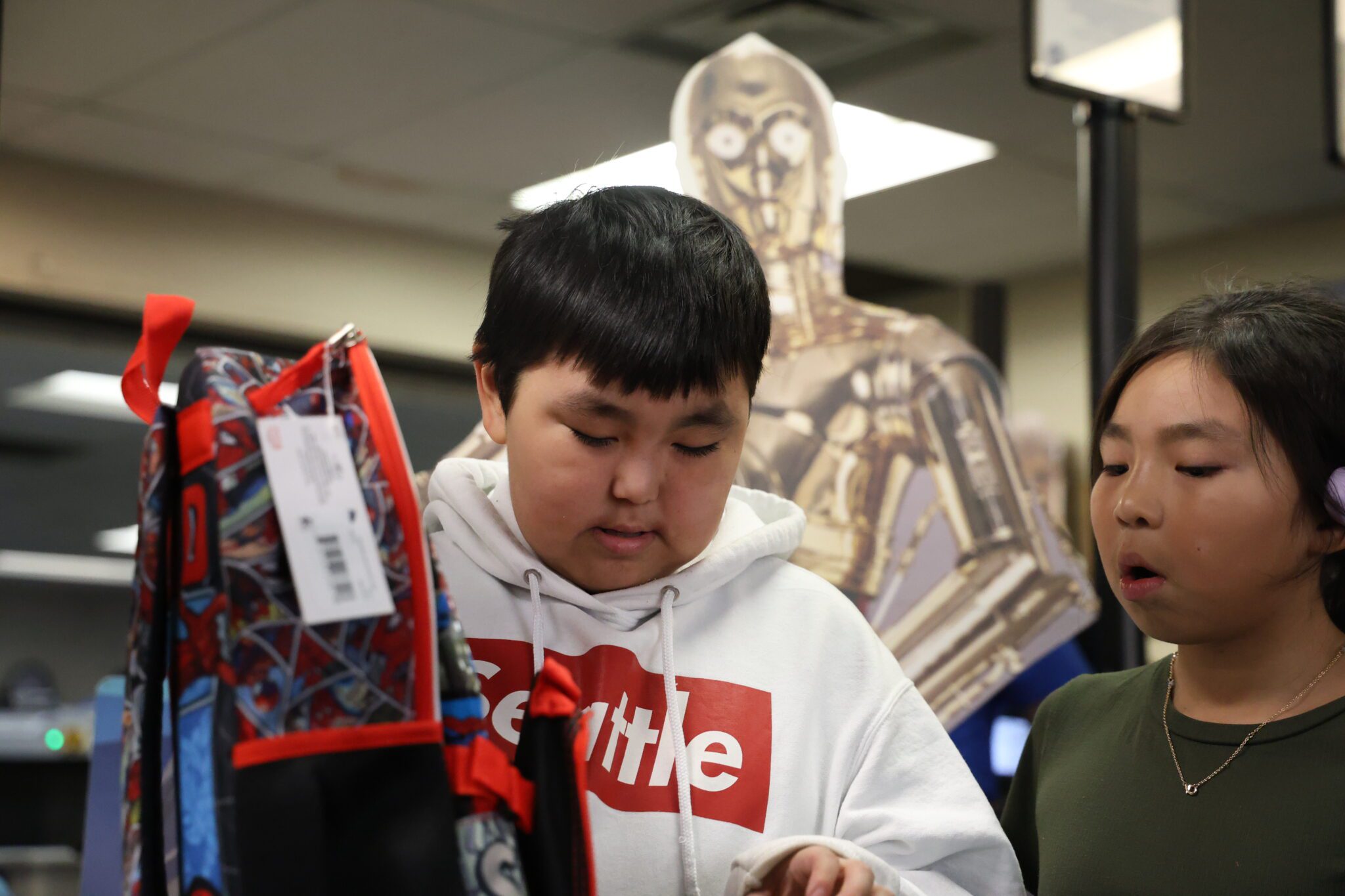 Owen Ningeulook checks out the contents of a gifted Spiderman backpack as his sister, Bianca Ningeulook looks on. Ben Townsend photo.