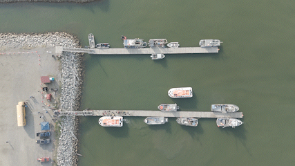 DJI_20250619090117_0097_D Passengers aboard orange-roofed tenders disembark at Nome's Small Boat Harbor.