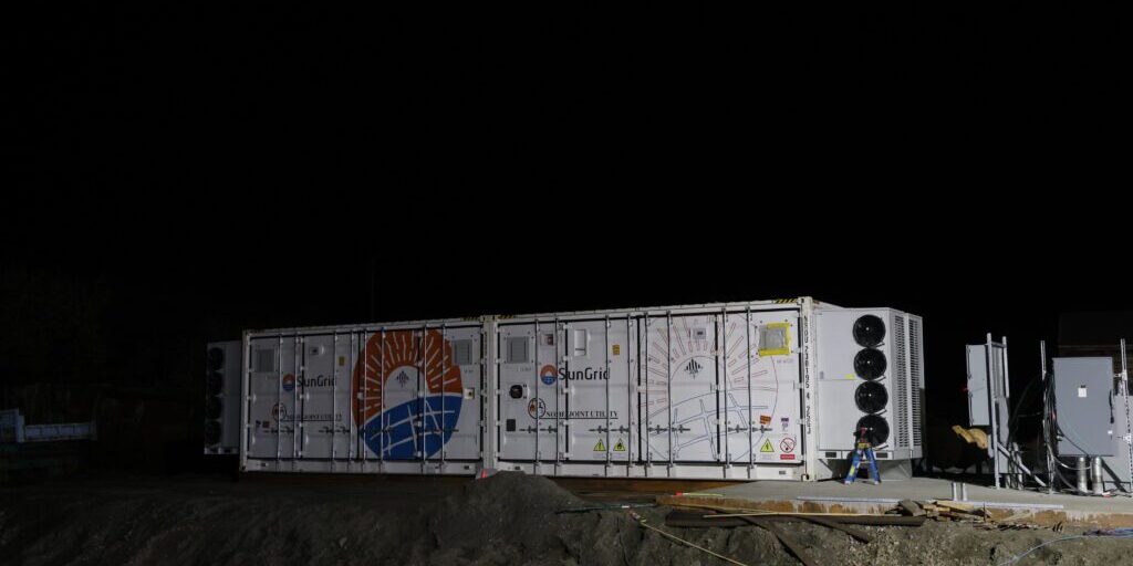 Two containers packed with batteries rest near a new concrete pad at Nome Joint Utility System's powerplant. Ben Townsend photo. 