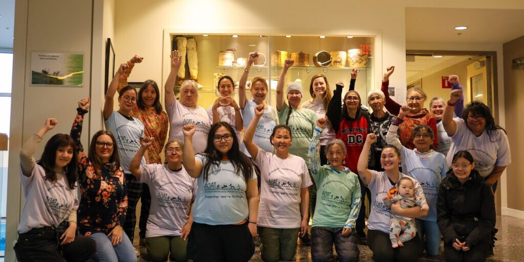 Participants of the 4th Indigenous Women and Girls Gathering hold closed fists in the air. Ben Townsend photo. 