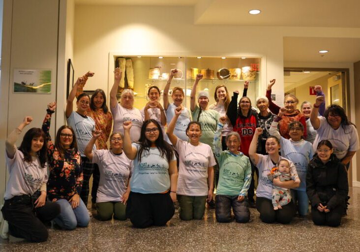 Participants of the 4th Indigenous Women and Girls Gathering hold closed fists in the air. Ben Townsend photo. 