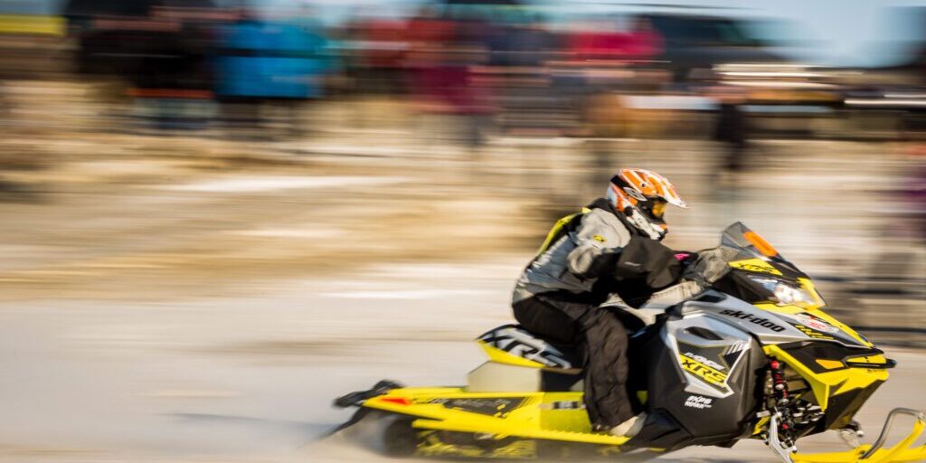 A snowmachine rider screams past the starting line of the Nome-Golovin Snowmachine Race.