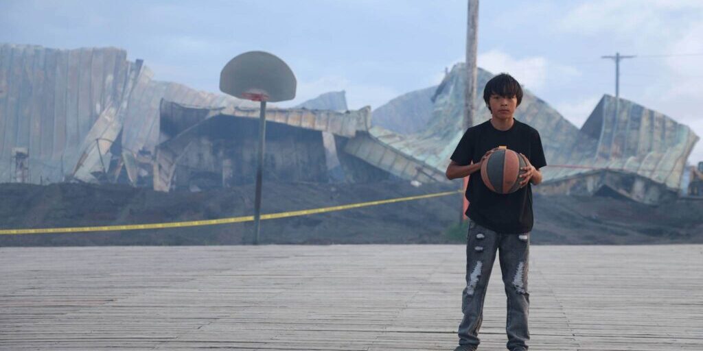 Stebbins School student Rydan Henry practices his basketball skills just feet away from what's left of his school. Ben Townsend photo.