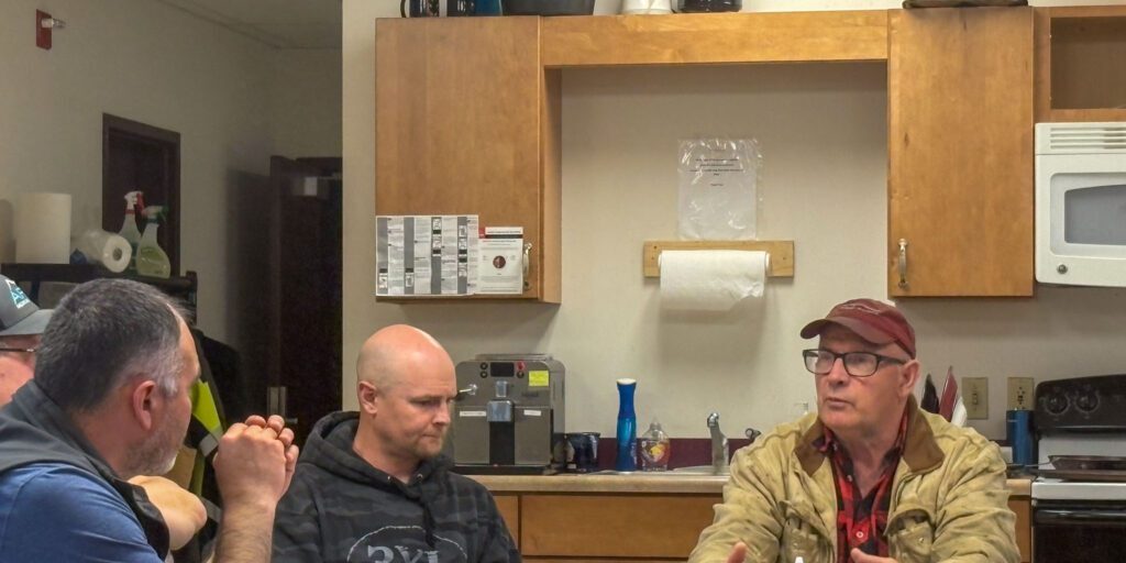 NJUS chair Carl Emmons deliberating with board members Derek McLarty, Dave Barron and Larry Pederson. Wali Rana photo.