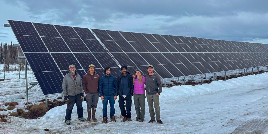 Brad Scotton, board member of Sustainable Energy for Galena, Alaska (SEGA), posing next to solar panels with the REAP team. Photo courtesy of Haleigh Reed. 