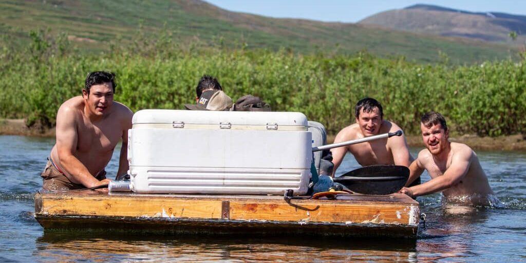 Da Boiz push their raft to the shore after hopping out for a traditional final dip in the river. Ben Townsend photo.