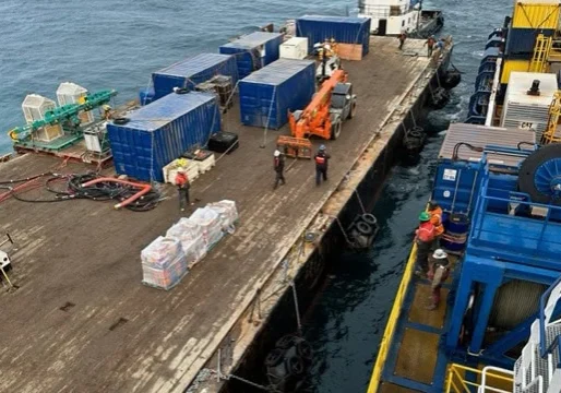 Workers aboard a barge transfer materials to a Quintillion-operated ship. Quintillion photo.