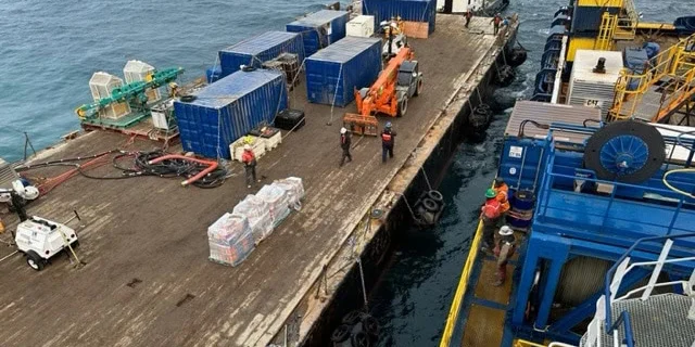 Workers aboard a barge transfer materials to a Quintillion-operated ship. Quintillion photo.