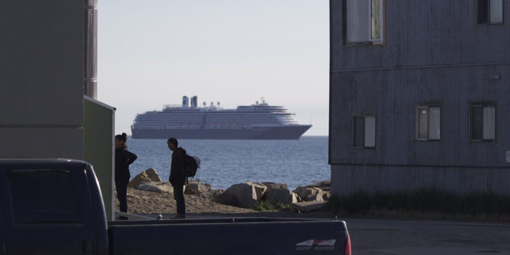 Residents of Nome converse as the MS Westerdam looms large in the background. Ben Townsend photo. 