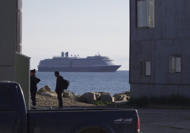 Residents of Nome converse as the MS Westerdam looms large in the background. Ben Townsend photo. 